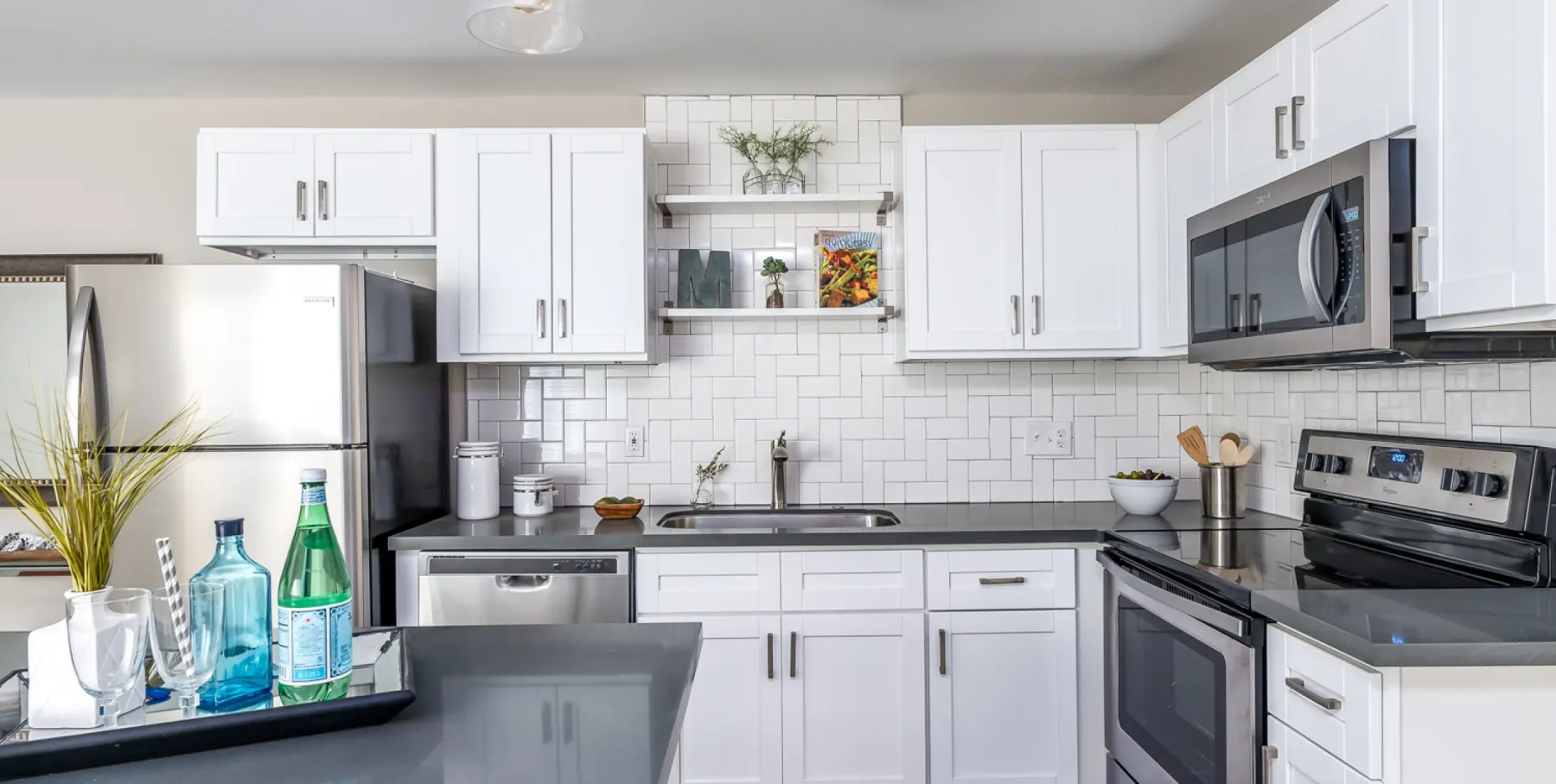 Renovated kitchen with white shaker cabinets, quartz counters, and stainless appliances